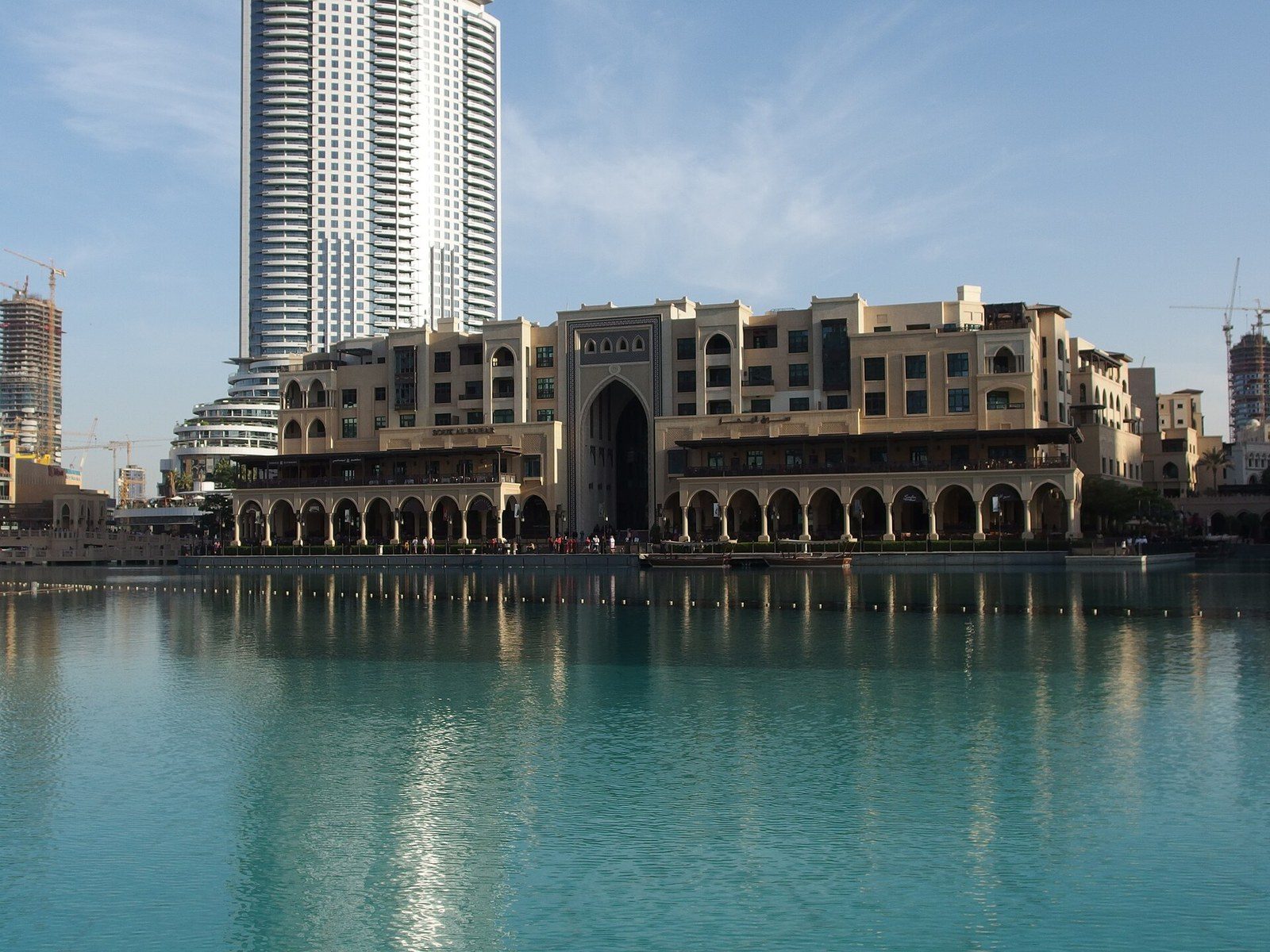 Best areas to visit in Dubai: Souk Al Bahar with its arches and a tall tower behind, reflected in a lake