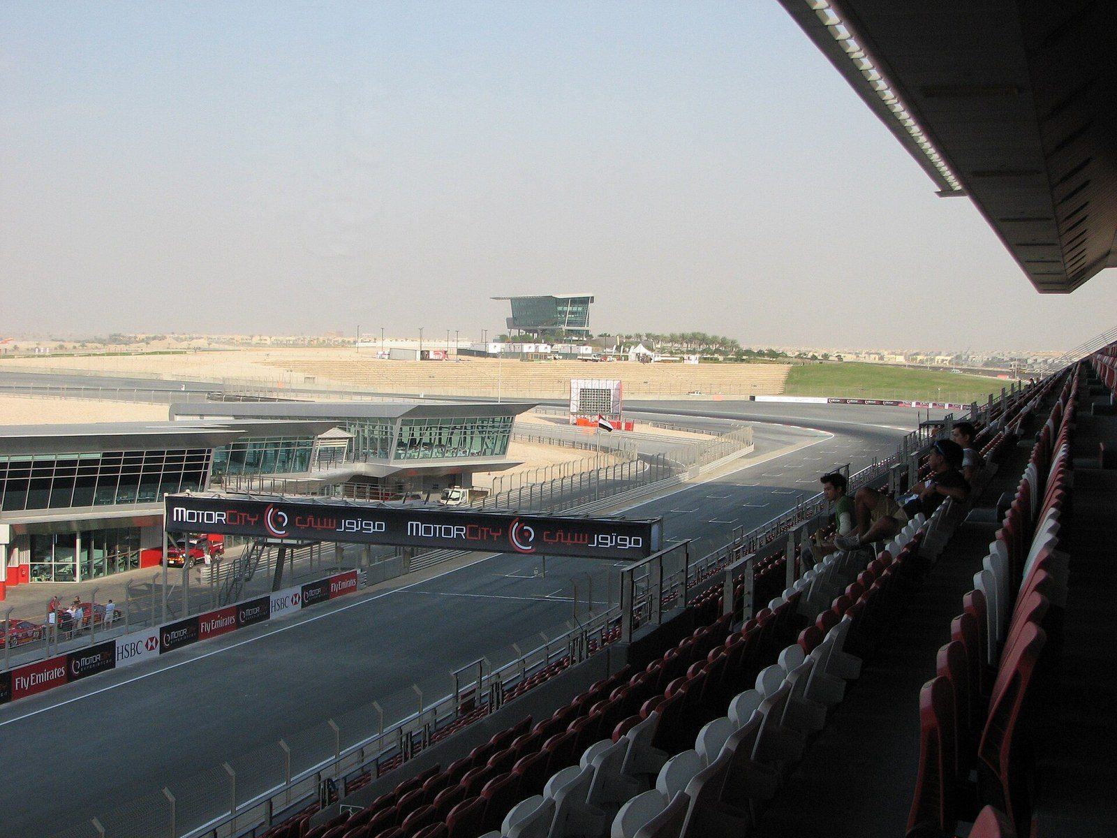 Dubai Autodrome: view from the grandstand over the finish straight, pit buildings and a tower in the distance