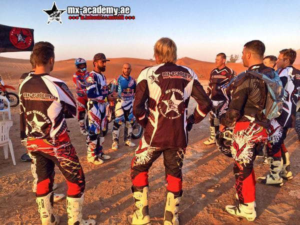 MX-Academy Dubai: riders in jerseys with the MX-Academy logo stand together in a circle on the desert sand