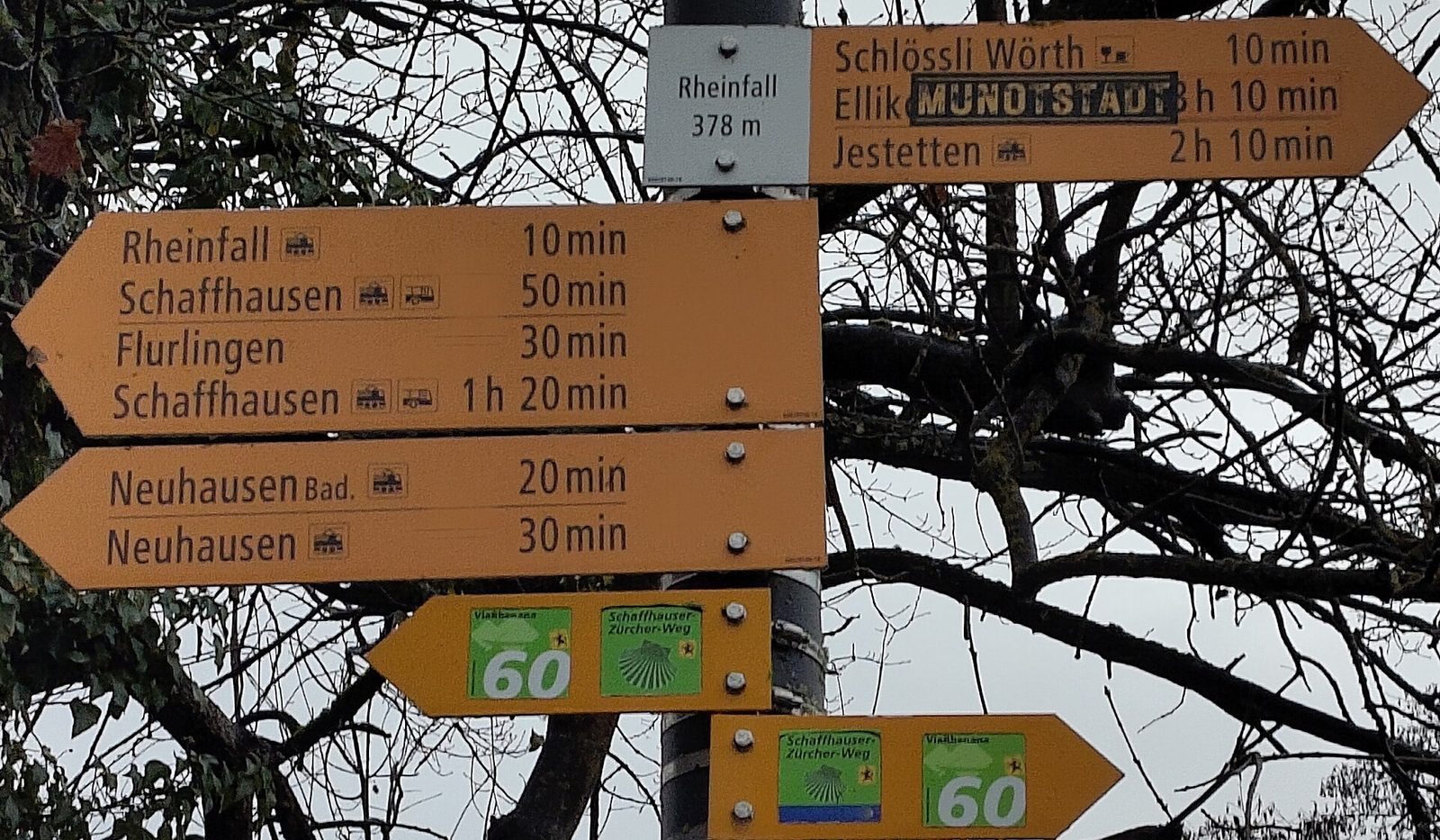 Outdoor activities in Switzerland on foot: yellow hiking signposts at the Rhine Falls showing walking times