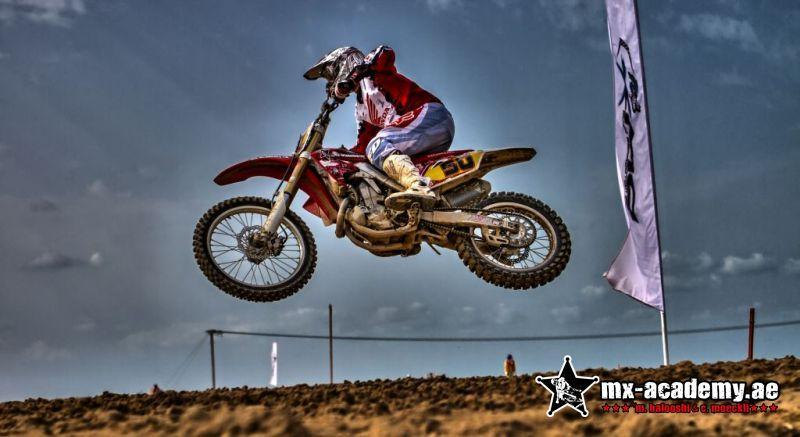 What to do in Switzerland for adrenaline seekers: a rider jumps a red bike with number 50 beside a tall flag