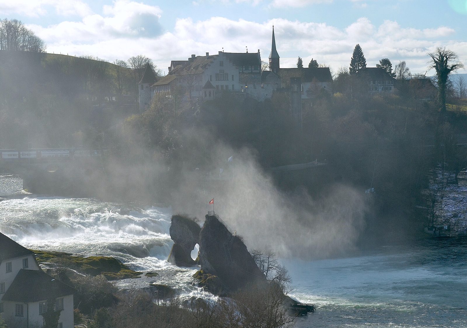 What to do in Switzerland in one day: spray rises around the Rhine Falls rock with Laufen Castle on the hill above